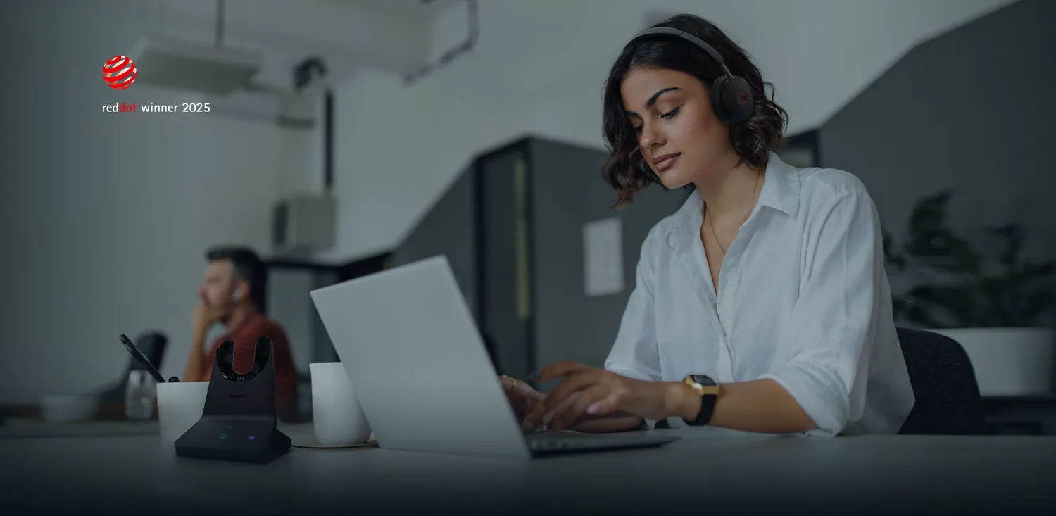 Office worker wearing a Yealink WH68 wireless DECT headset on a softphone call